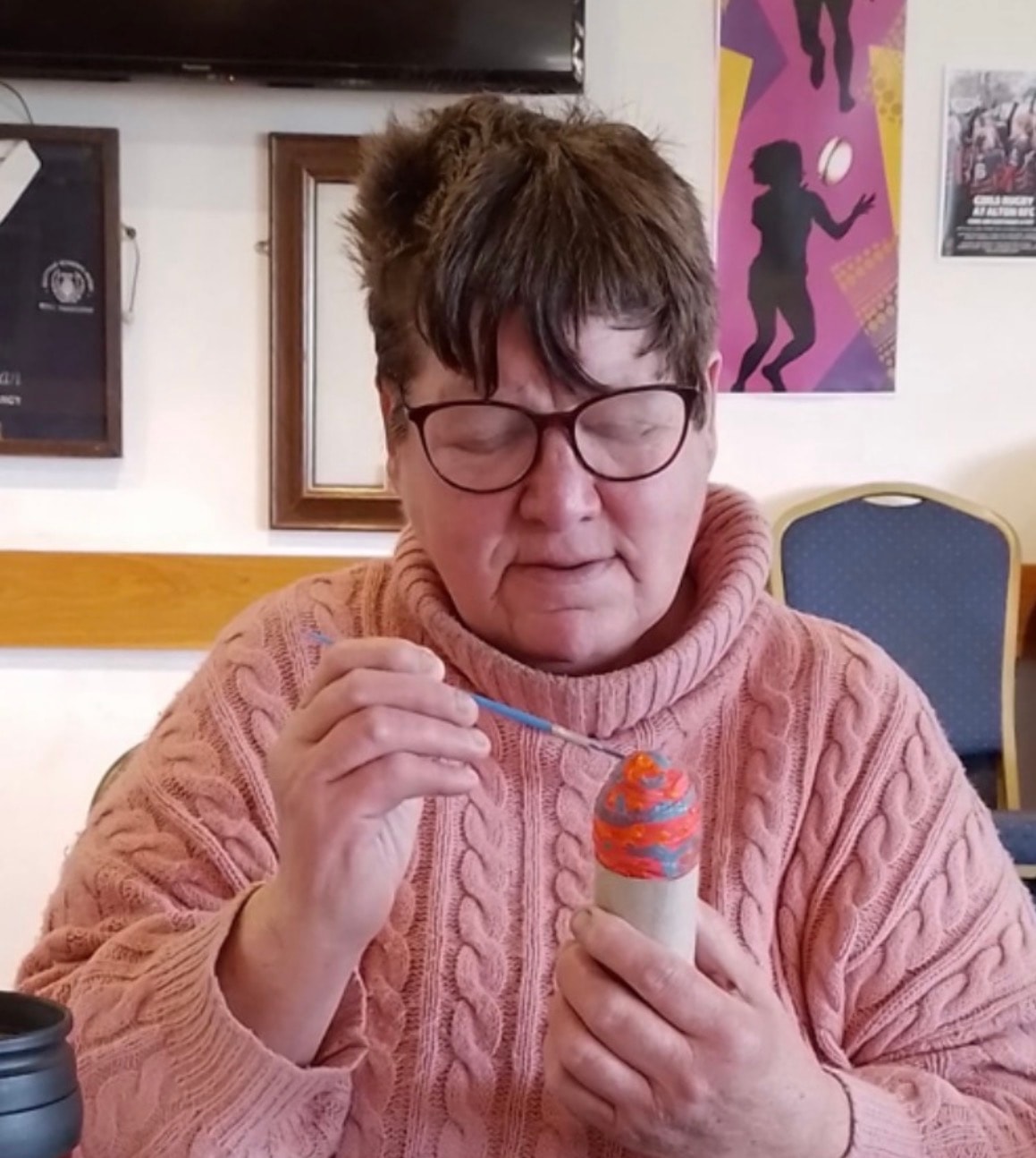Community member painting a pot at a craft session